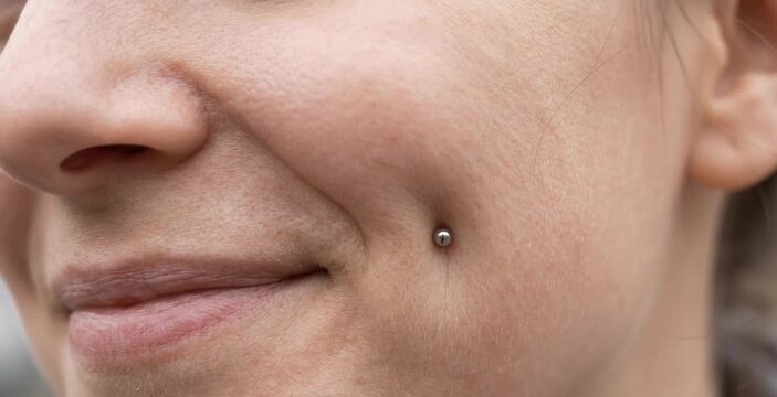Close Up of Smiling Woman Cheek Showing Dimple Piercing with Silver Dermal Stud Anchor