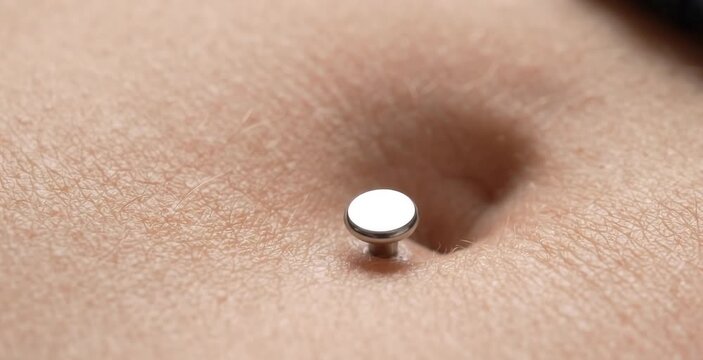 Macro Close Up of Flat Silver Disc Dermal Top Navel Belly Button Piercing