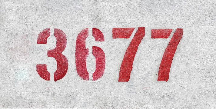 red spray-painted number 3677 sprayed onto a white wall.