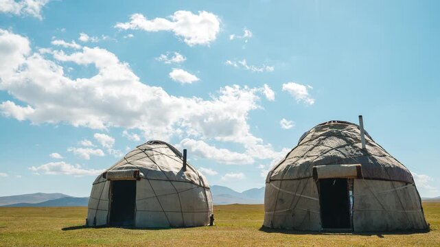 White clouds in the blue sky are flying over the nomads&rsquo; yurts, time‑lapse