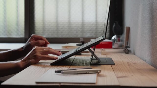 Hand Resting Near Tablet on Wooden Desk 4K