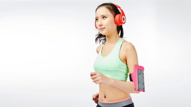 Woman Running on Treadmill with Armband and Headphones