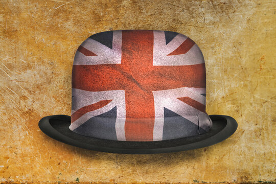 Vintage black bowler hat decorated with the English national flag on a weathered background
