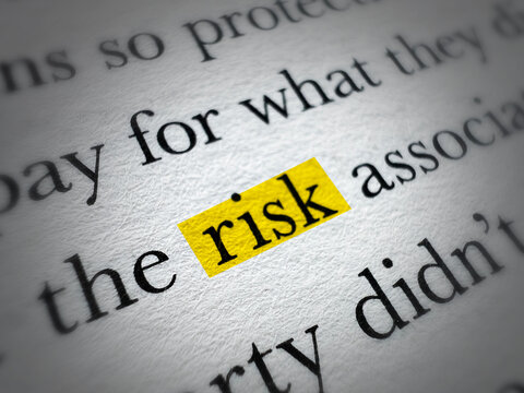 Close up of paper text with the word risk highlighted in yellow marker concept background for finance insurance business safety word risk highlighted on page
