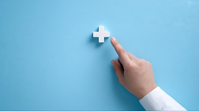Hand pointing at white plus symbol on blue background healthcare concept