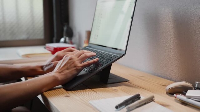 Hands Typing on Laptop Keyboard at Wooden Desk Slow Motion 4K