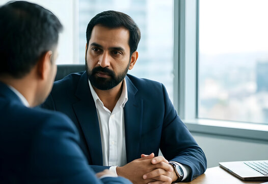 Corporate collaboration and business negotiation, two professional men in suits having a serious discussion in a modern office with city view background
