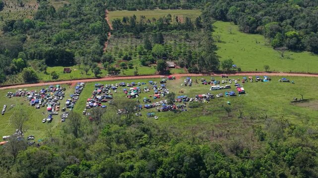 Rally camping area with parked vehicles and tents in Nueva Alborada, Paraguay, aerial panoramic overview