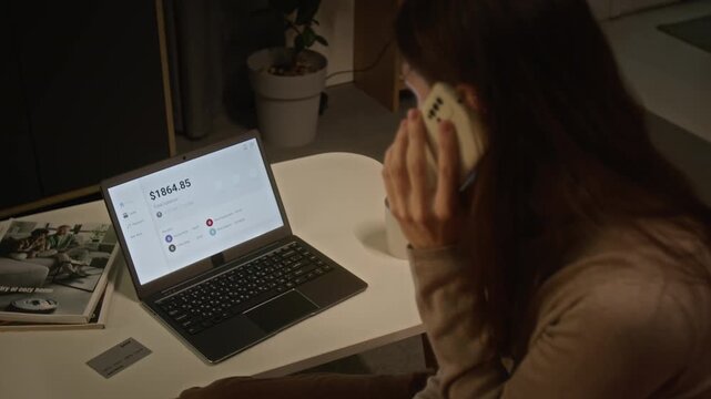 Young Caucasian woman calling bank support in panic while watching money balance drop to zero on laptop. Ideal for cyber fraud awareness and financial scam campaigns