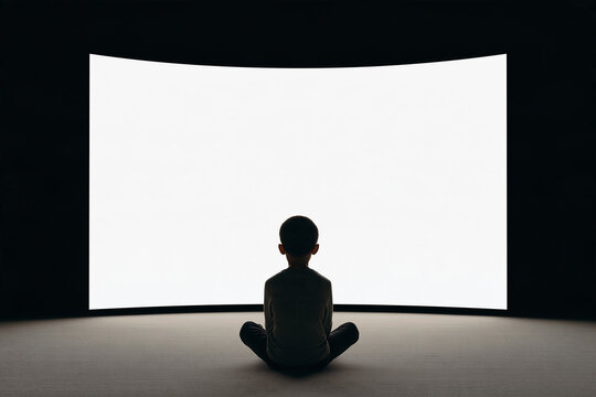 Silhouette Of Child In Dark Room Watching Bright Blank Curved Screen
