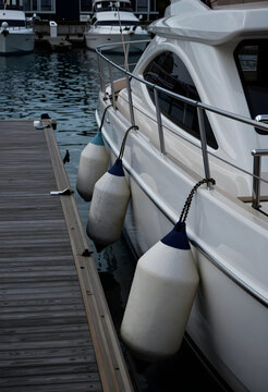 Luxury yacht travel and maritime leisure, white boat moored at wooden pier with protective fenders for docking in a calm marina harbor during summer