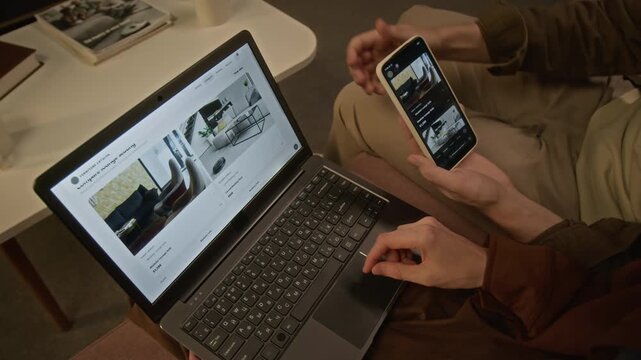 Cropped shot of unrecognizable couple browsing online furniture store using laptop and smartphone from high angle view. For e-commerce advertising and digital consumer experience campaigns