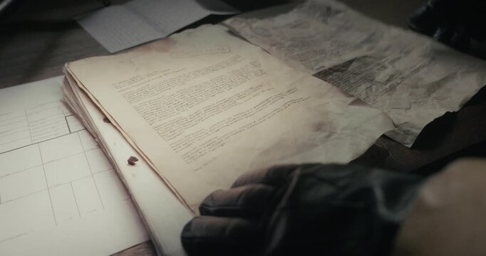 Gloved figure searches old confidential UFO documents across a desktop in dark shadows, evoking covert investigation, intelligence gathering and mystery storytelling.