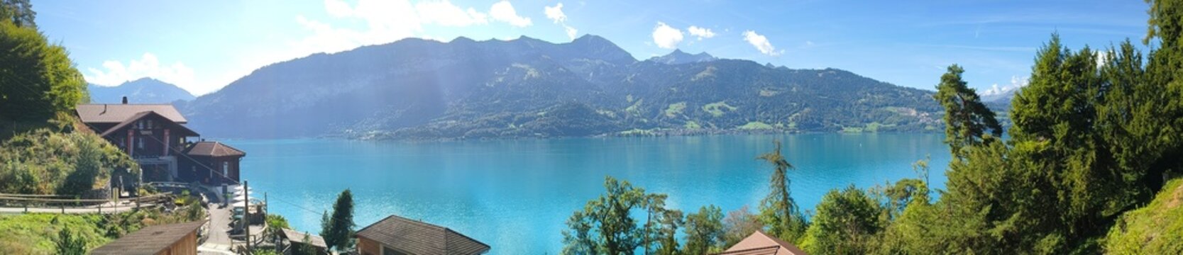 Lago alpino con case in legno e montagne sotto cielo sereno
