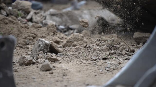 A shovel is digging into a pile of dirt. The dirt is brown and rocky