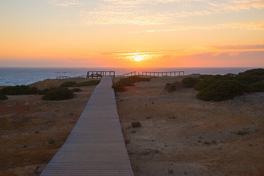 sunset scenery at West Algarve coast, atlantic ocean, portugel. wooden boardwalk
