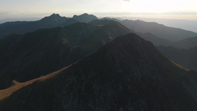 Dark summit foreground with layered mountains