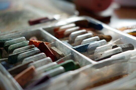 Close up view of colorful poster paint tubes stored neatly in a palette box