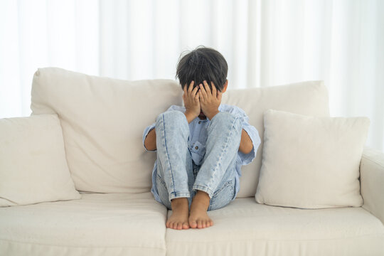 Bullying awareness, sad asian boy sitting alone hugging knees, child mental health, psychological trauma, emotional distress, depression symptom, social isolation, school violence and silent victim