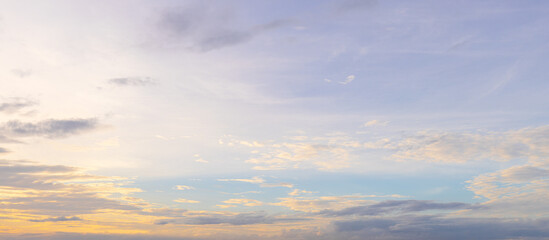 Fototapeta premium Soft sunset sky with golden glow and pastel purple clouds,A beautiful panoramic view of a soft sunset sky featuring a warm golden glow near the horizon blending into gentle pastel purple and light.