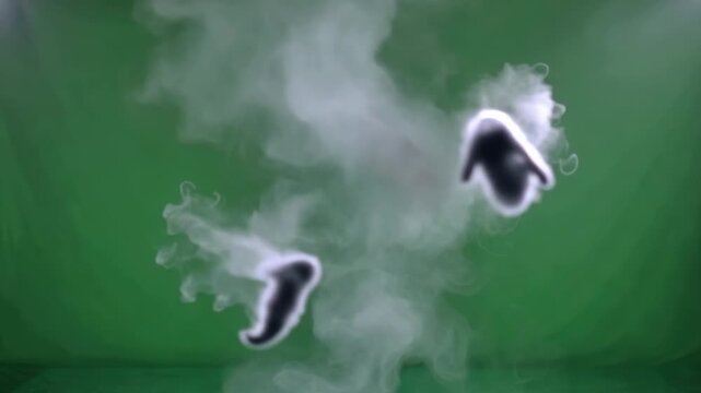 Close up smoke swirling in a green field background.
