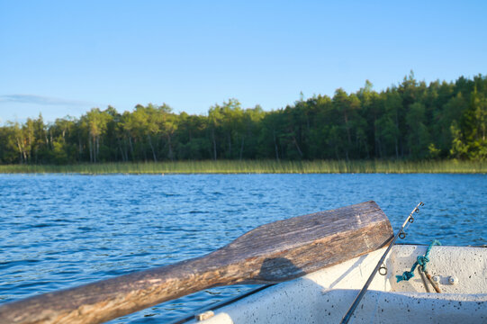 Rowing Boat with Wooden Oar on Calm Forest Lake, in sweden, in Sunny Evening Light.