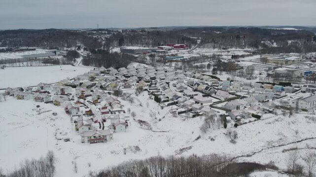 Snow-covered residential neighborhood with houses and roads in winter landscape