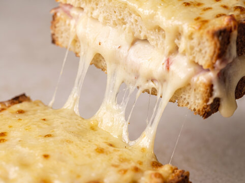 Hot grilled cheese sandwich pulled apart showing melted stringy cheese