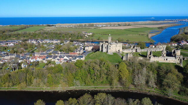Aerial view of Warkworth Castle, Warkworth village, and the River Coquet loop leading to the North Sea, Northumberland, England, UK