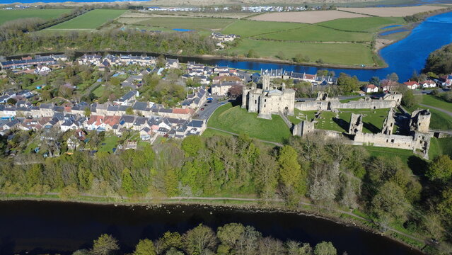 Aerial view of Warkworth Castle, Warkworth village, and the River Coquet loop leading to the North Sea, Northumberland, England, UK