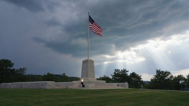 American flag at memorial under stormy sky