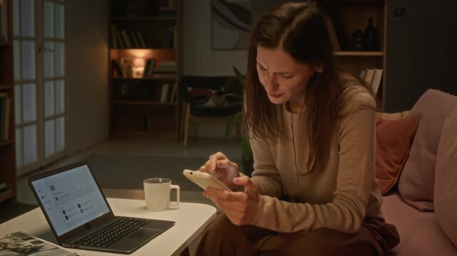 Caucasian young woman checking smartphone and laptop, reacting with distress to bad news. Footage suitable for advertising debt relief, cyber scam awareness, or fintech apps