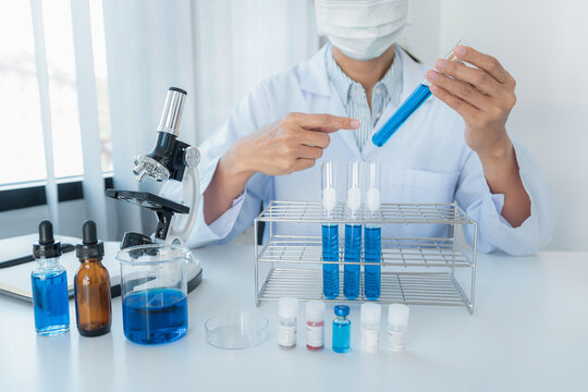 Scientist woman in medical face mask is experiment produce coron