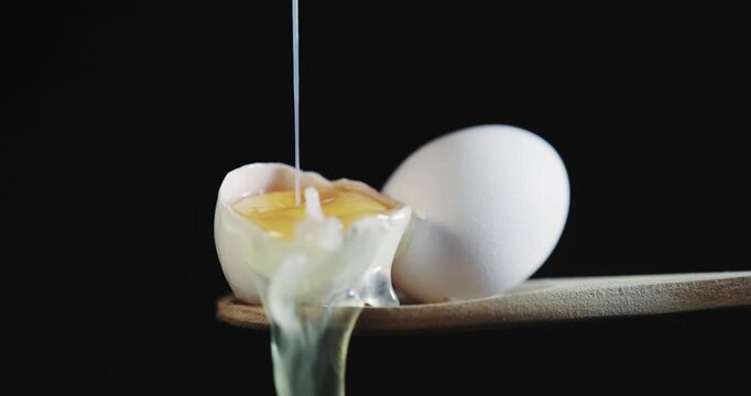 A half-eaten egg with a small hole in it sits on a wooden cutting board