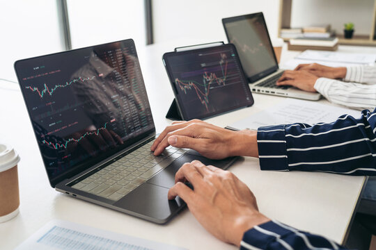 Business trader team are using laptop to checking stock market o