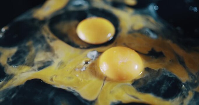Two eggs are sitting on top of a black surface