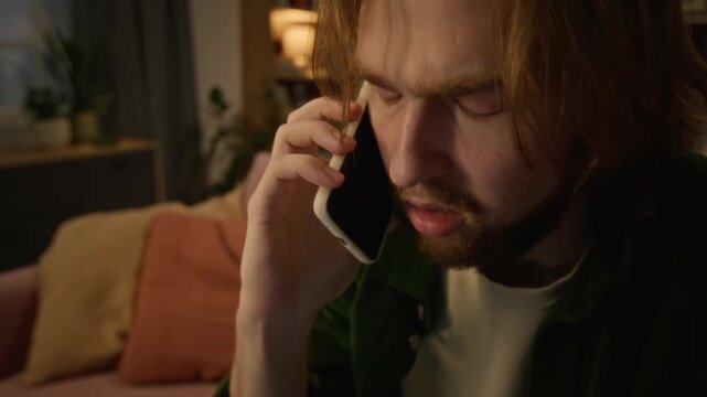 Young Caucasian man talking on smartphone looking stressed during serious phone call. Clip suitable for customer support campaigns and mobile telecom advertising