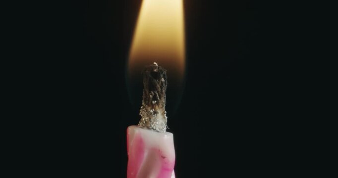A candle is lit and the flame is yellow