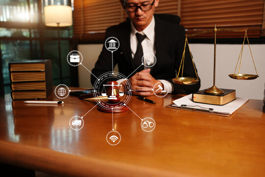 Asian Lawyer Sitting at Desk with Scales of Justice and Connected Digital Icons