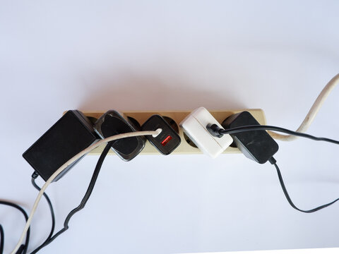 Overloaded Power Strip with Multiple Chargers and Plug Adapters