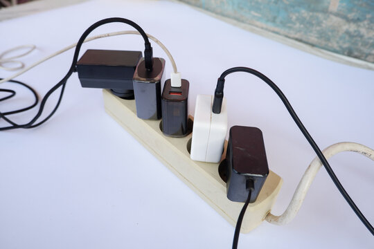 Overloaded Power Strip with Multiple Chargers and Plug Adapters