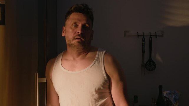 Portrait of middle aged Caucasian man suffering from alcohol abuse, wiping forehead with hangover and staring. Clip perfect for addiction recovery and mental health rehabilitation videos