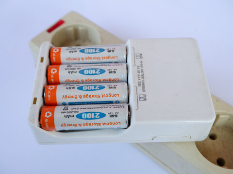 Recharging AA Batteries in Portable Charger on Electrical Power Socket Strip for Electronic Device Energy Supply