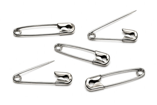 Silver metal safety pins scattered isolated on white background.