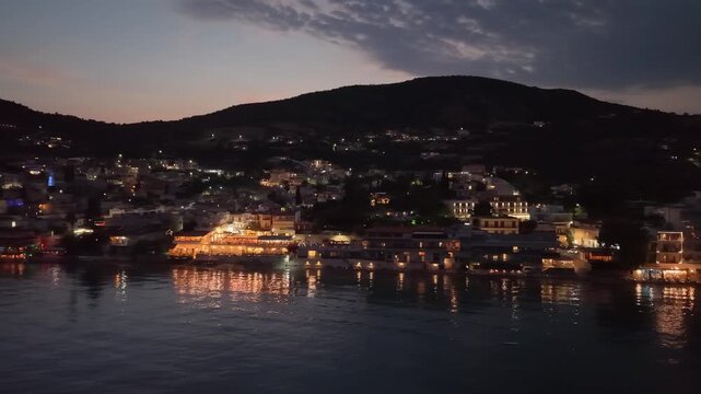 Aerial footage of waterfront with city lights by the Aegean sea, Greece