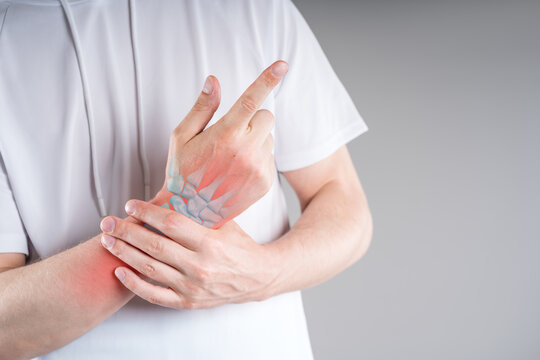 Pain in wrist of man, with illustration anatomical joint and bones with red backlight. Carpal tunnel syndrome medical concept