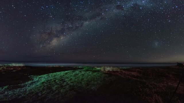 The beauty of the Milky Way galaxy stretching across the coastal horizon at night. Clusters of brightly sparkling stars fill the clear night sky, free from urban light pollution.