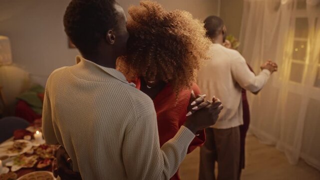 Young adult African American couple slow dancing together during Thanksgiving dinner party. Clip suitable for holiday advertising campaigns and festive lifestyle promotions