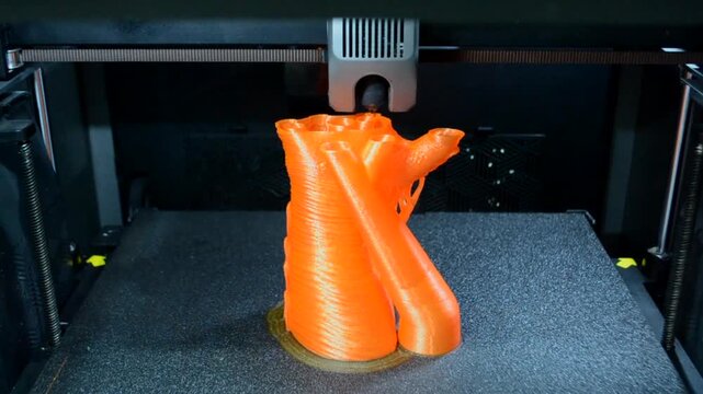 Process printing on 3D printer. The 3D printing process from molten plastic orange color. 3D printing technology. FDM technologies. Fused Deposition Modeling. Additive manufacturing.