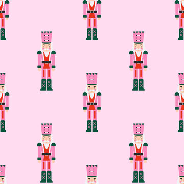 Seamless pattern of wooden nutcracker soldier toys on light pink background. Cute Christmas character backdrop suitable for festive wrapping paper holiday textiles and party decor.